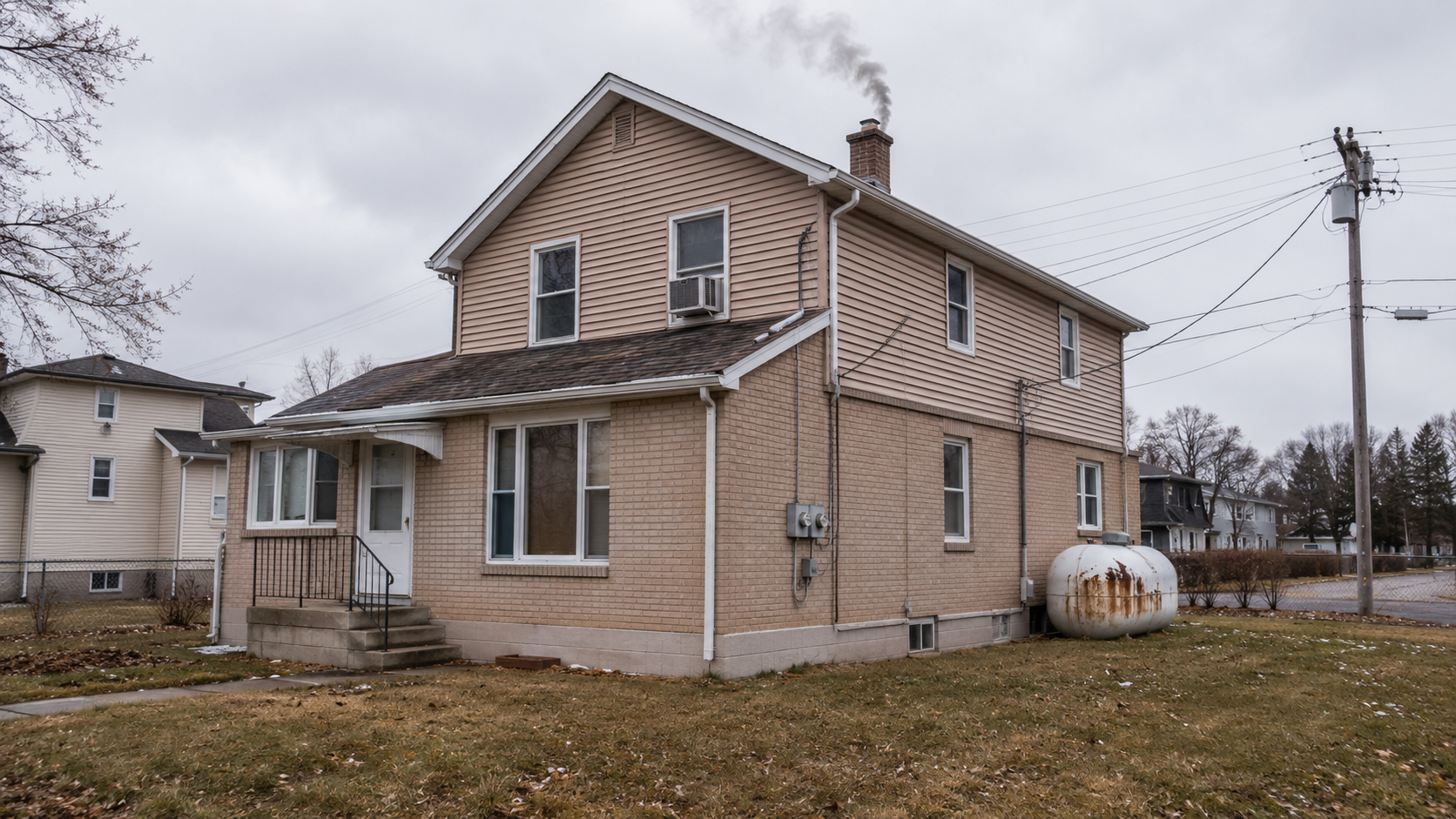 An ordinary house exterior in flat winter daylight, smoke rising from the chimney, fully dependent on the grid